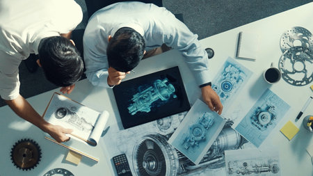 Time lapse of smart project manager sitting while colleague walking at meeting. Professional engineer looking at turbine engine or electronic generator while colleague asking question.の写真素材