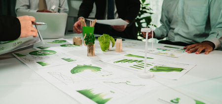 A professional business team engages in a productive discussion around charts and graphs in a modern...