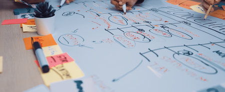 A vibrant team engages in a strategic planning session, using colorful sticky notes and markers to visualize project timelines and goals in a collaborative office space.の写真素材