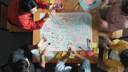 Top down view of business team working together by using mind map brainstorming idea and sharing...