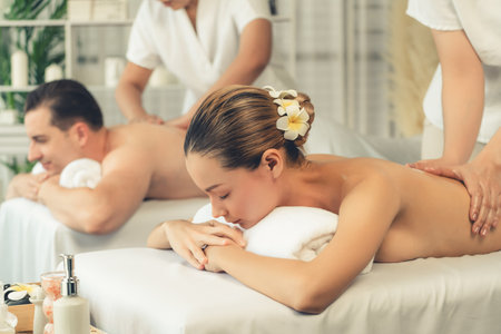 Caucasian couple customer enjoying relaxing anti-stress spa massage and pampering with beauty skin recreation leisure in day light ambient salon spa at luxury resort or hotel. Quiescentの写真素材