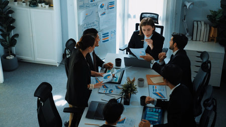 Top view of investor handed financial document to manager while explain marketing idea at meeting table. Diverse people looking at growing graph while listen business team discussion. Directorate.の写真素材