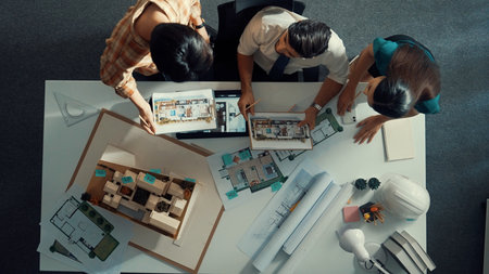 Top down view of skilled businessman and colleague designing house together. Aerial view of architect engineer working and measuring building structure by using architectural equipment.の写真素材