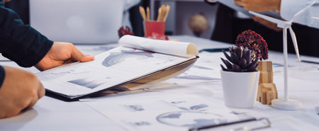 Engaging scene of a business meeting focusing on financial reports and sustainability strategies, showcasing teamwork and collaboration in a modern workspace.の写真素材