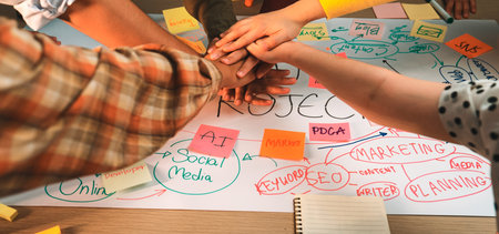 A dynamic team engages in collaborative project planning with sticky notes and colorful markers, discussing marketing strategies and sharing creative ideas around a table.の写真素材