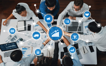 A diverse team engages in a productive business meeting, analyzing data and developing strategies with modern technology in a contemporary office environment.の写真素材