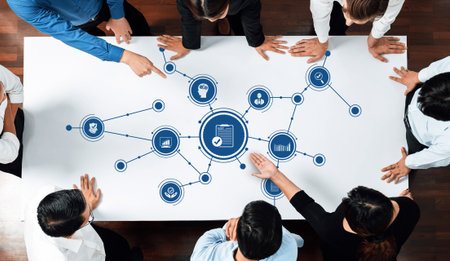 A diverse group of professionals is engaged in a collaborative business meeting. They analyze data,...