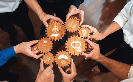 A diverse group collaborates by holding gears with symbols representing ethics, creativity, and protection in a harmonious setting, highlighting teamwork and innovation.の写真素材