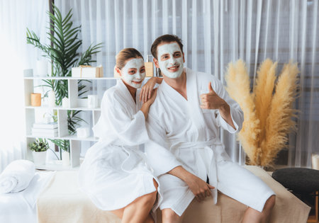 Blissful couple in bathrobe with facial cream mask enjoying serene ambiance of spa salon resort or...