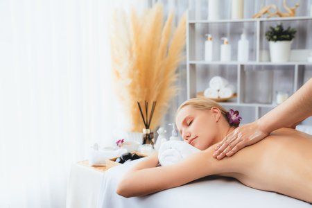 Caucasian woman customer enjoying relaxing anti-stress spa massage and pampering with beauty skin recreation leisure in day light ambient salon spa at luxury resort or hotel. Quiescentの写真素材