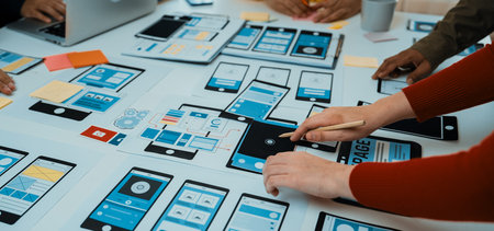 Team members engage in a user interface design session, exploring mobile prototypes, using sticky...