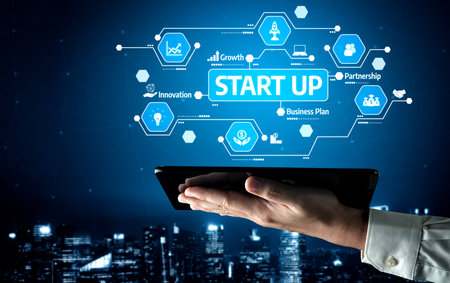 A hand holds a tablet displaying startup graphics, showcasing innovation and strategic growth in...