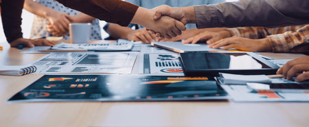 A powerful business handshake symbolizes agreement and collaboration among colleagues in a modern office setting, highlighting teamwork, strategy, and shared goals.の写真素材