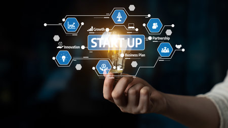 A creative representation of startup innovation featuring a hand holding a light bulb, surrounded by...