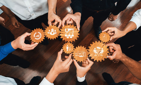 This image captures hands holding gears symbolizing collaboration in management. Perfect for visualizing teamwork, strategy, and growth in a business context.の写真素材