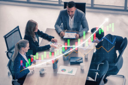 A diverse team collaborates in a modern office, analyzing financial graphs and strategies during a...