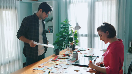 Top view of smart designer holding color palette while project manager looking at design and choosing color for program. Professional businesswoman taking a note while design creative logo. Symposium.の写真素材