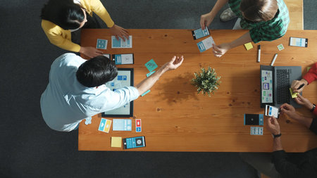 Programmer sharing Ux Ui design for mobile phone interface idea with software developer at meeting while designer writing idea at sticky notes. Start up team develop wireframe prototype. Convocation.の写真素材