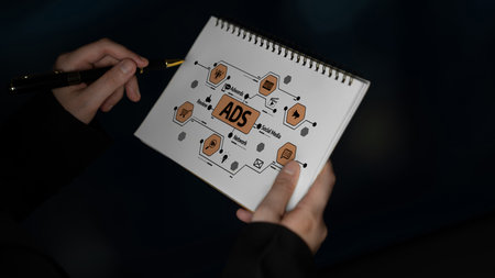 A person holds a notebook filled with a creative sketch relating to advertising concepts,...
