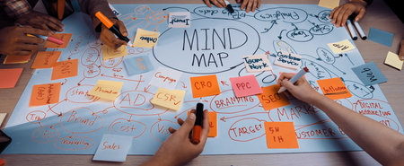A diverse group works together on a mind map for marketing strategy, showcasing vibrant notes and tools. This collaborative setting emphasizes creativity and planning. SACTRの写真素材