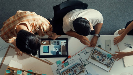 Top down view of skilled business man and colleague design house together. Aerial view of architect engineer working and measuring building structure by using architectural equipment.の写真素材
