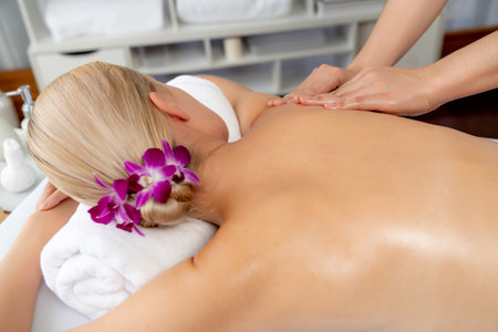 Closeup woman customer enjoying relaxing anti-stress spa massage and pampering with beauty skin recreation leisure in day light ambient salon spa at luxury resort or hotel. Quiescentの写真素材