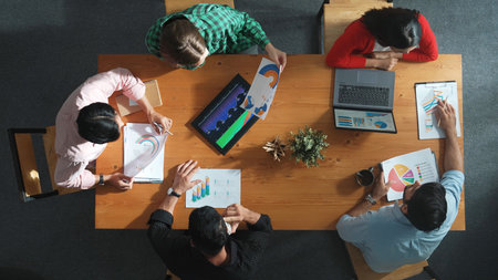 Top down view of business woman explain and present financial chart. Diverse group discuss and...