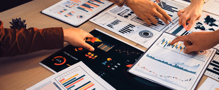 A group of professionals engaging in collaborative analysis over various business charts and graphs...