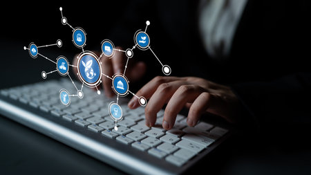 A close-up image of a person typing on a keyboard, illustrating digital connections and icons that...
