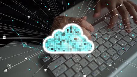 A person hands typing on a keyboard with a vibrant cloud graphic, symbolizing digital data transfer...