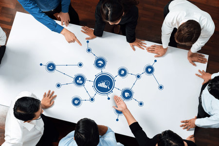 A top-down view of a team collaborating on business strategies with various icons symbolizing...