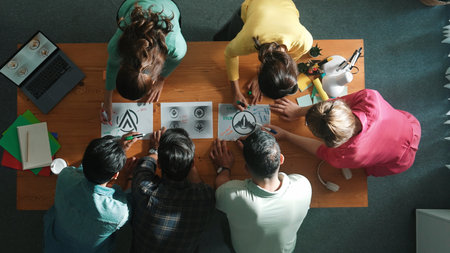 Top view of smart business team put graphic logo on meeting table and start to design while explain...