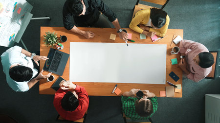 Top down aerial view of diverse business team designing and planning project while skilled manager...