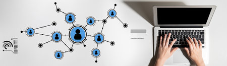 Aerial view shows hands typing on a laptop among a digital network graphic, illustrating the essence...