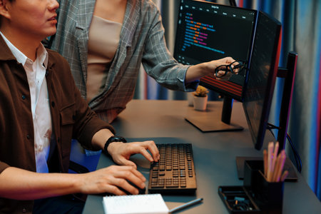 IT developers discussing with point to intelligent website development coder system running data...