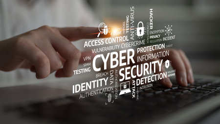 Hands typing on a keyboard are surrounded by various cybersecurity terms and icons, illustrating the...
