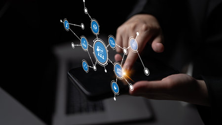 A person interacting with a smartphone featuring digital connectivity icons, illustrating the...