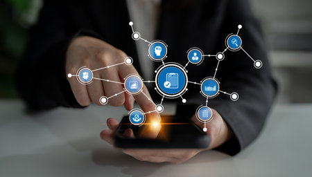 A professional individual interacts with a smartphone that displays a digital network of icons,...