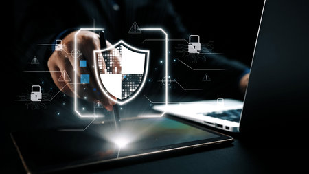 A businessperson interacts with a tablet to visualize a cybersecurity shield, demonstrating modern...