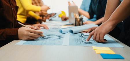 A group of professionals engaged in a collaborative planning session, discussing charts and...