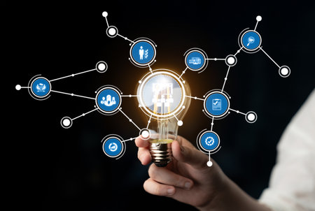 A hand holding a lightbulb with interconnected digital icons symbolizing innovation, technology, and...
