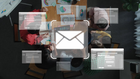 Aerial view of a collaborative team meeting focused on digital marketing strategies, featuring email...