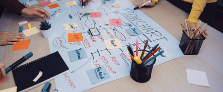 A diverse team engages in a brainstorming session, using sticky notes and charts to plan projects....