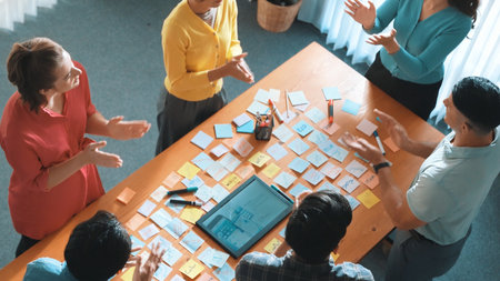 Aerial view of developer team discussing and showing digital program and writing by using Ux Ui...