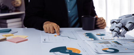 A human and a robotic hand collaborate in a dynamic business meeting, discussing data charts and...