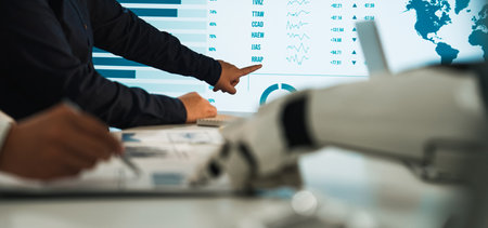 Professionals engage in data analysis, utilizing a robotic hand and digital screen to navigate...