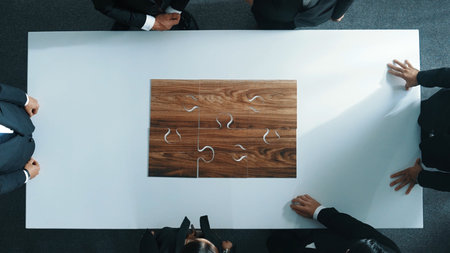 Top view of business people putting jigsaw together at meeting room. Professional marketing team...