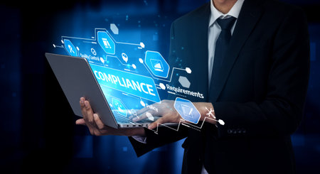 Professional businessman in a suit holds a laptop featuring virtual graphics on compliance...