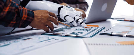 A close-up view of a collaborative workspace showcasing a human hand and a robotic arm working...
