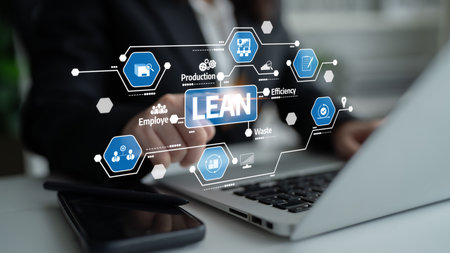 A focused business professional utilizes a laptop, implementing lean management strategies while...